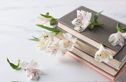 Beautifully crafted memoir books alongside fresh flowers
